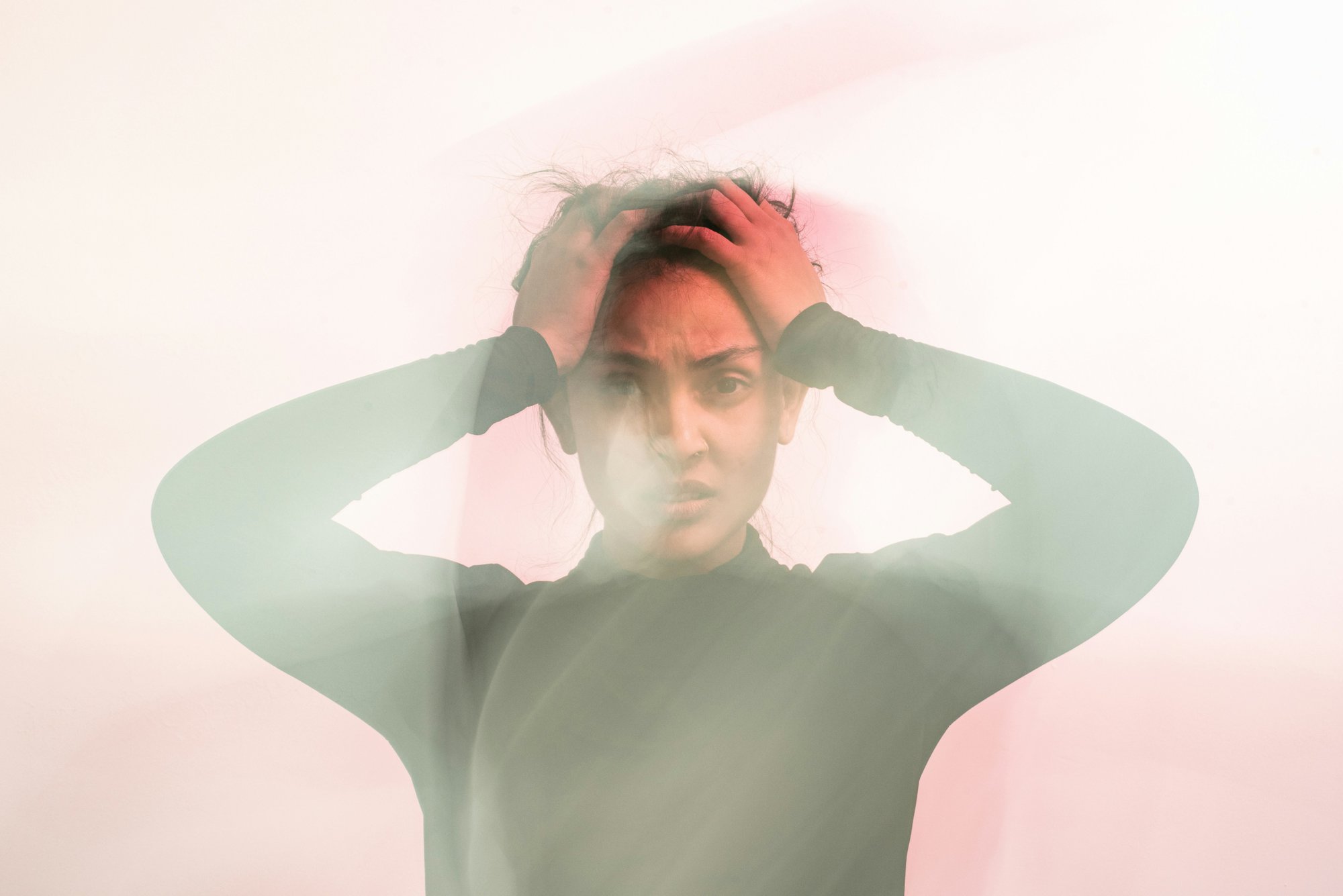 Blurred woman with her hands to her head looking anxious