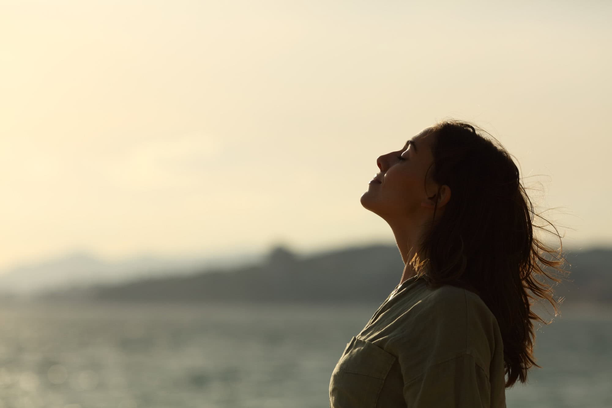 woman silhouette on a beach breathing fresh air